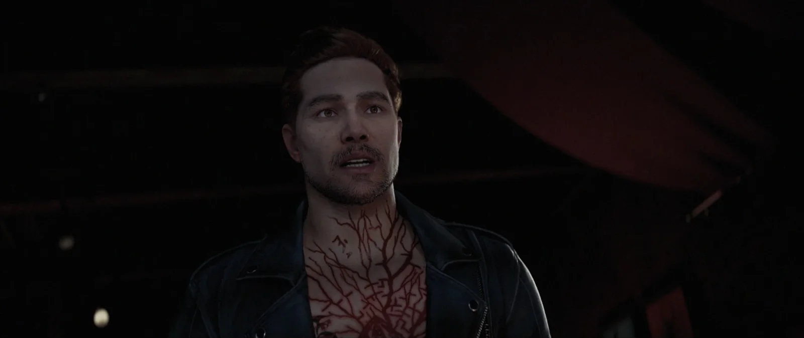 Aidan Lynch in a leather jacket, branching red marks spreading across his chest and throat