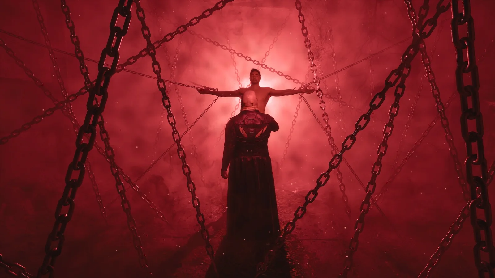 A shirtless man held up by chains in a red fog, arms spread wide, with a robed figure standing below him