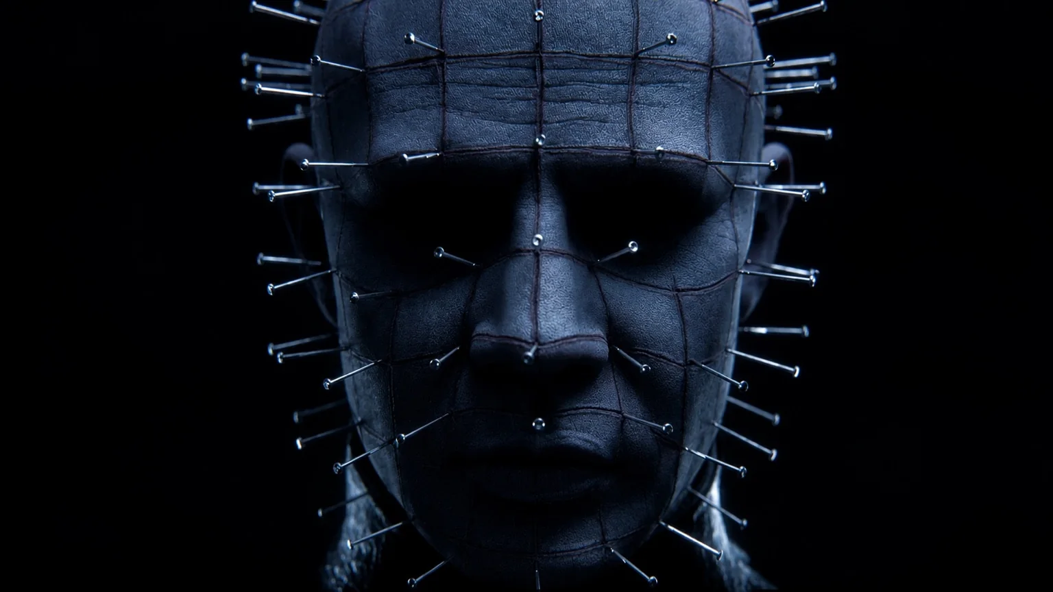 Pinhead's face in close-up, the pins in his scored grey skin catching the light against pure black